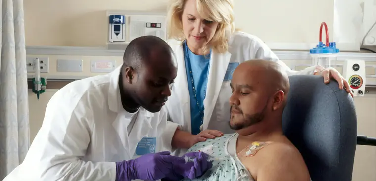 Two clinicians attending a patient at the bedside